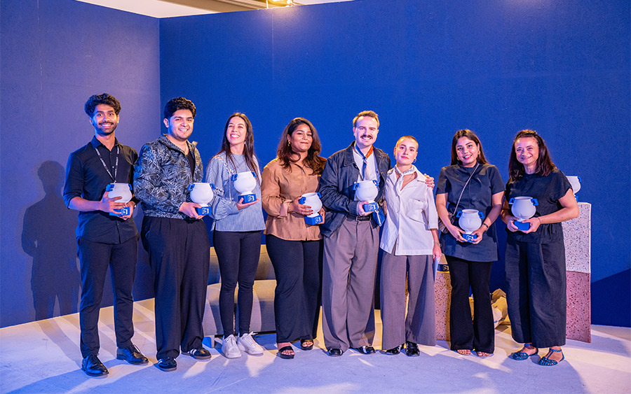 I vincitori del 2024 posano con il trofeo Isola Design Awards di quell’edizione, un vaso bianco con manici e base blu